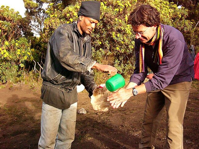 Stephan washing his hands with the help of Michael
